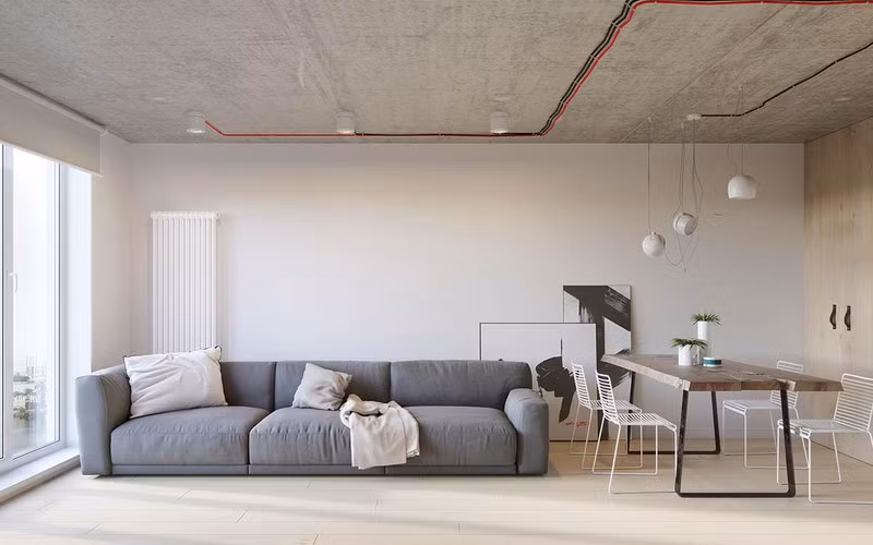 Bàn ăn gỗ mộc mạc đặt cạnh ghế sofa là kiểu bố trí phổ biến trong những căn hộ hiện đại.