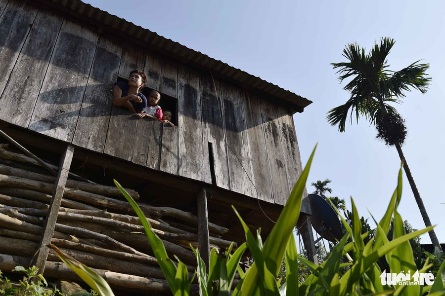 Khi biết có người đến nóc, nhiều người dân nhìn qua ô cửa sau nhà - Ảnh: LÊ VĂN ÁNH