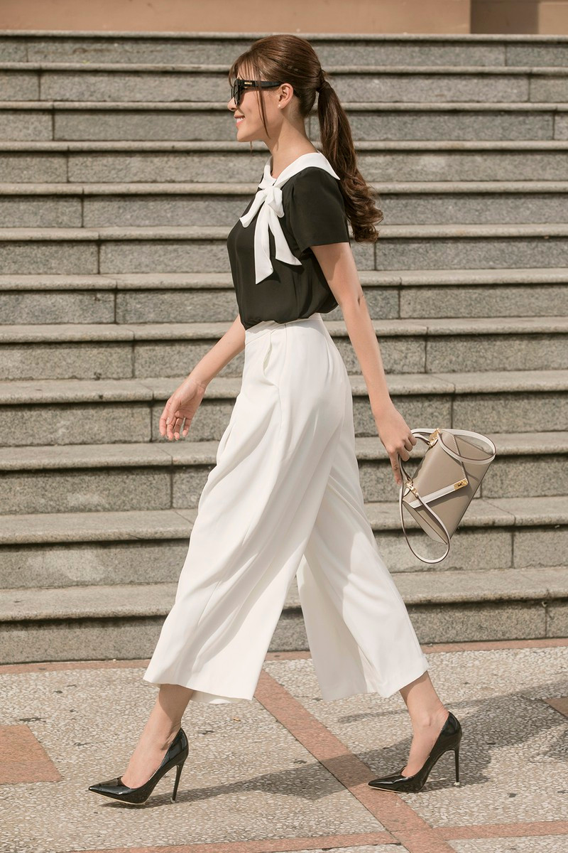 Phụ kiện đi kèm của set này là chiếc túi màu ghi thanh lịch cùng cặp kính mát với phom hình mắt mèo hiện đại, sang trọng.