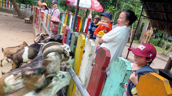  Phụ huynh đưa con đi chơi ở Thảo cầm viên (TP.HCM) - Ảnh: THANH ĐẠM