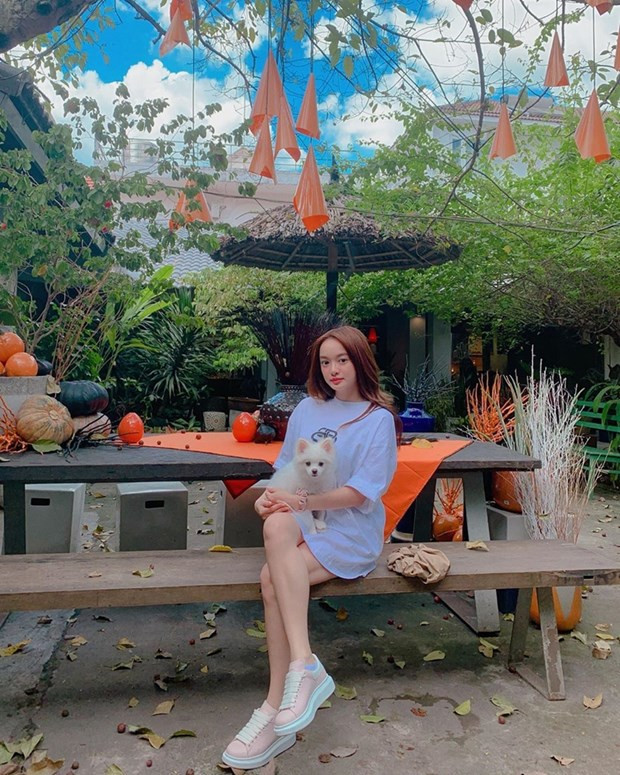 Kaity Nguyễn tạo hiệu ứng tăng chiều cao nhờ biến áo phông dáng rộng thành đầm, kết hợp giày sneakers phóng khoáng.