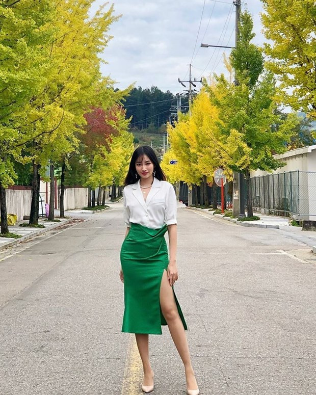 Trúc Diễm biến tấu bộ đôi sơmi-chân váy công sở có phần cứng nhắc bằng cách chọn kiểu chân váy xẻ hông cao, phủ sắc xanh tươi sáng. Chỉ cần thêm một đôi giày cao gót cổ điển, người đẹp đã có được trang phục tôn vẻ lịch thiệp song không kém phần quyến rũ.