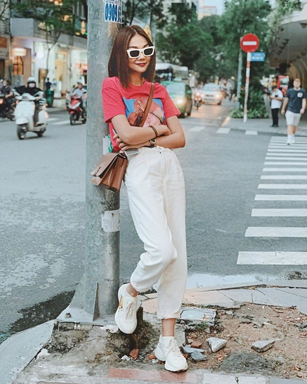 Thanh Hằng ''hack tuổi'' với street style trẻ trung, năng động, Siêu mẫu diện áo phông họa tiết và quần xắn gấu, mix cùng giày thể thao trắng của Gucci.