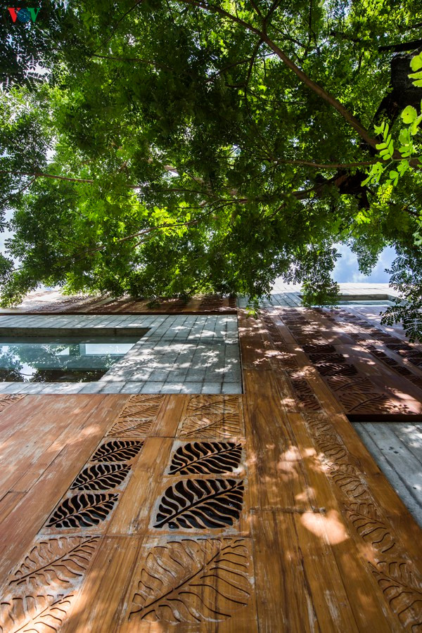 Mặt ngoài công trình ngoài những mảng tường gạch xây được đan xen với những mảng ốp gỗ, tạo nên hiệu quả khác biệt. Cây xanh xung quanh nhà vừa làm đẹp cảnh quan và góp phần ngăn bức xạ nhiệt cho nhà thêm mát.