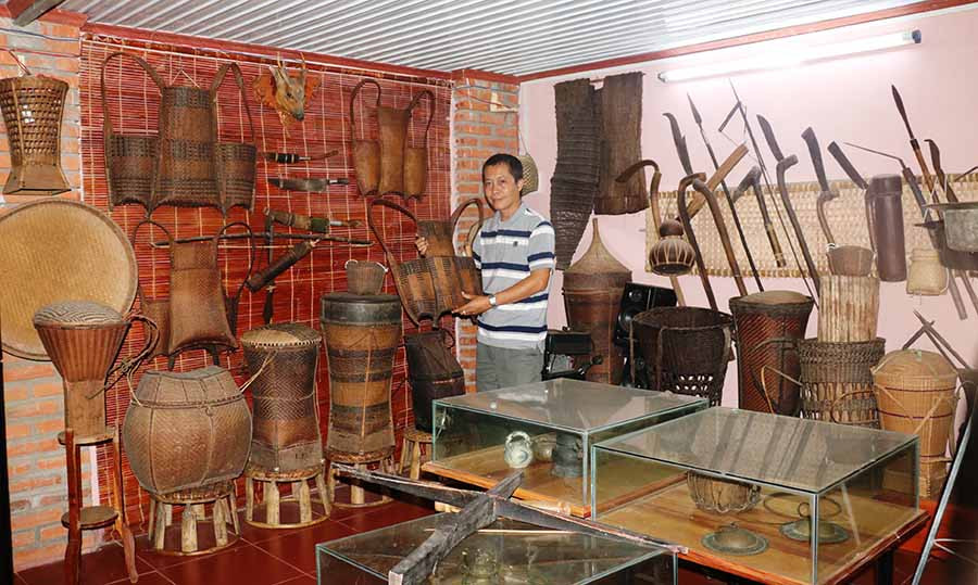 Anh Nguyễn Thế Phiệt bên bộ sưu tập các dụng cụ lao động của đồng bào dân tộc thiểu số. Ảnh: A.H