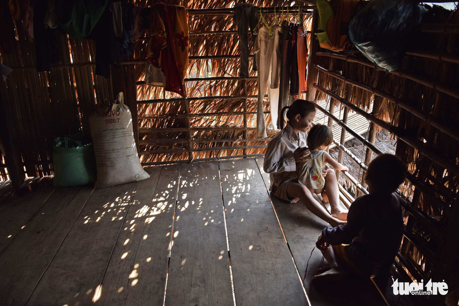 Những đứa trẻ nhìn ra ngoài từ một căn nhà vách lá đơn sơ - Ảnh: LÊ VĂN ÁNH