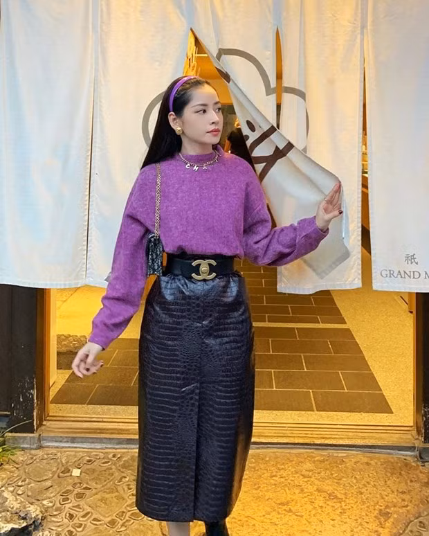 Chi Pu hóa tiểu thư vintage với chân váy da, kết hợp chiếc áo len tím pastel cùng bờm cài ton ton-sur-ton. Cô nàng khéo léo điểm xuyết vòng cổ và thắt lưng Chanel, vừa tôn eo thon vừa nhấn nhá nét cổ điển.