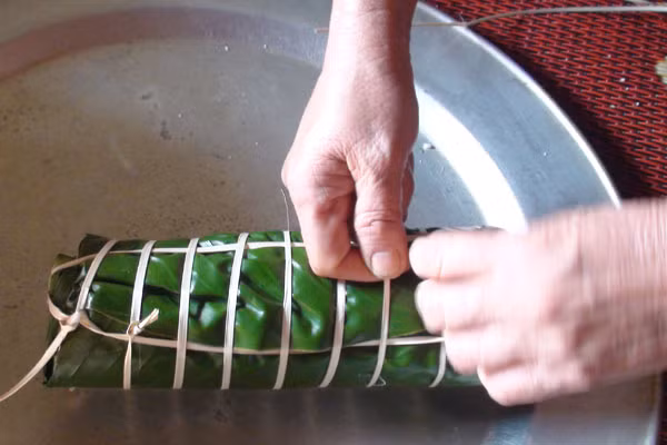 Mỗi chiếc bánh chưng được gói bằng 4 lá dong to bản và có màu xanh thẫm, còn bánh tày thì chỉ gói bằng 3 lá. Ảnh: Trần Dung