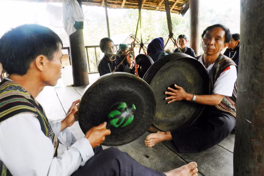 Đồng bào H'rê sinh hoạt ở nếp nhà sàn tiện hơn nhà trệt (đánh chiêng, thổi kèn bên nếp nhà trong mùa xuân về). Ảnh: Trường An