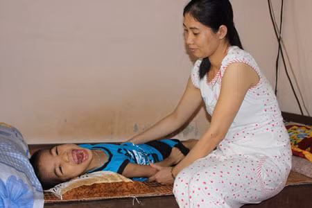 Chất độc dioxin đã nhiễm đến thế hệ thứ 3 (cháu nội bà Sự cười vô hồn khi thấy khách lạ). Ảnh: Trường An