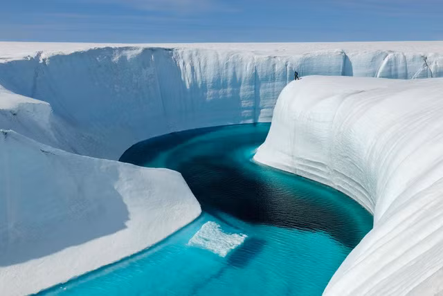 Một nhà khoa học đứng ở hẻm Birthday để khảo sát sự tích lũy cryoconite - một trầm tích làm từ đá, bồ hóng, và các vi khuẩn tích tụ trên đá băng và tuyết.