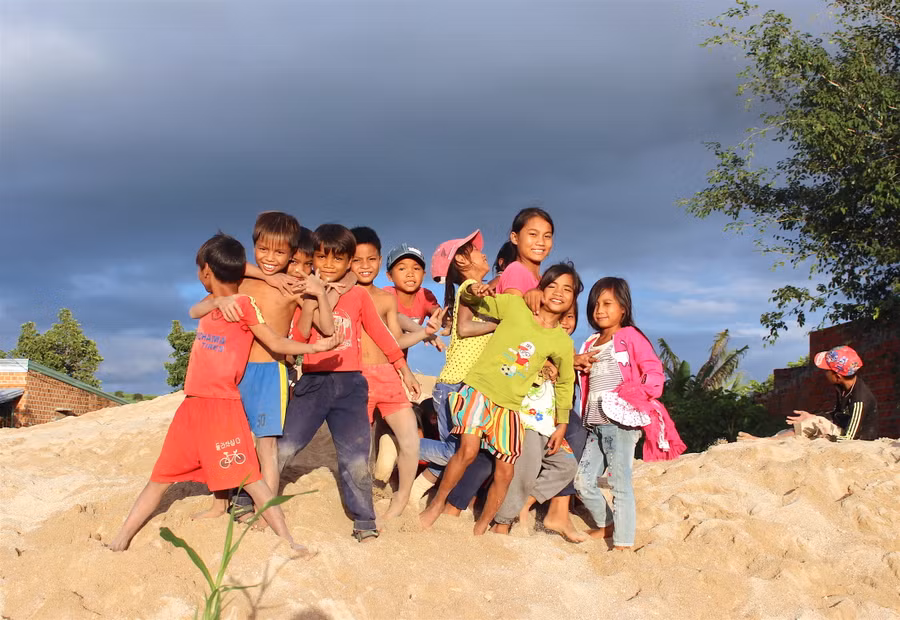 Tiếng cười giòn tan hiếm hoi của bọn trẻ khi đùa nghịch trên đồi cát đầu làng. Ảnh: Hồng Thi