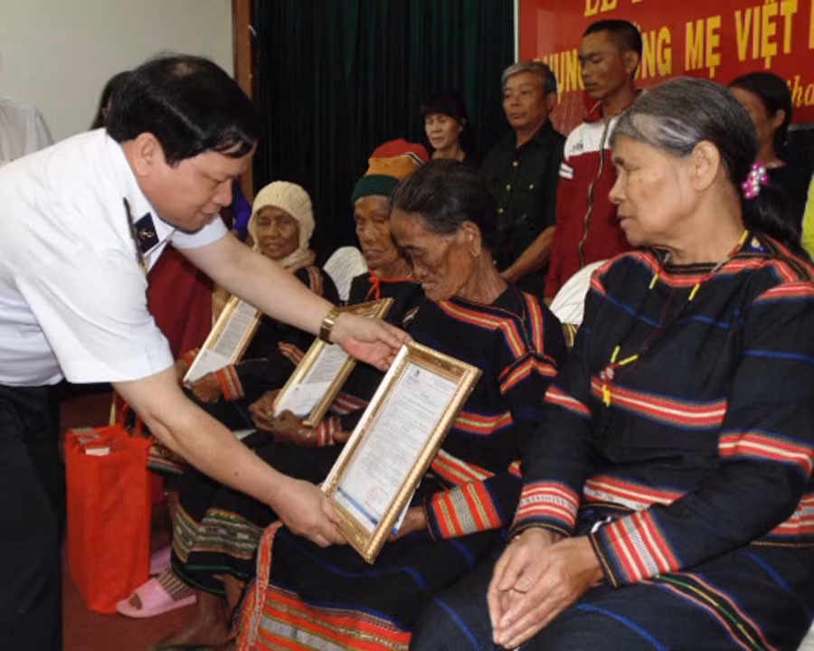  Đại tá Chủ nhiệm Chính trị Lê Cao Thịnh trao quyết định phụng dưỡng cho các mẹ. Ảnh: T.N