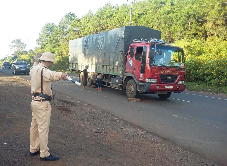 Trung tá Nguyễn Minh Tuấn điều tiết giao thông tại nơi xe tải bị mất thắng. Ảnh: Lê Anh 1trung tá Nguyễn Minh Tuấn điều tiết giao thông tại nơi xe tải bị mất thắng. Ảnh: Lê Anh
