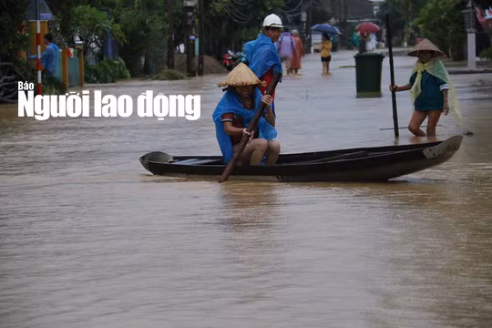 Người dân đi thuyền giữa mưa lũ