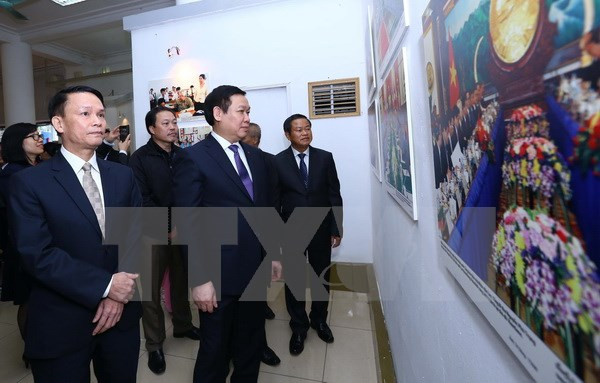 Phó Thủ tướng Vương Đình Huệ (giữa), Tổng Giám đốc Thông tấn xã Việt Nam Nguyễn Đức Lợi (trái) cùng các đại biểu tham quan triển lãm.