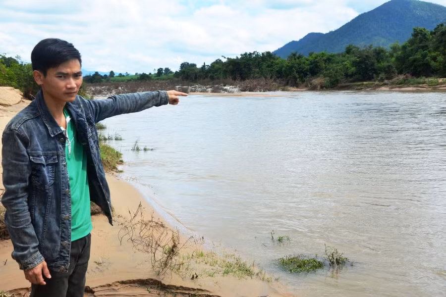 Anh Nguyễn Văn Kiên chỉ về đoạn suối Ia Mlah, nơi anh đã dũng cảm lao mình theo dòng lũ để cứu sống 5 học sinh lớp 7. Ảnh: Đ.P