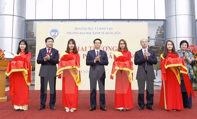  Phó Thủ tướng Vũ Đức Đam và các đại biểu thực hiện nghi thức cắt băng đặt biển tên Thư viện Phạm Văn Đồng của nhà trường. 