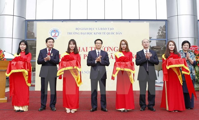  Phó Thủ tướng Vũ Đức Đam và các đại biểu thực hiện nghi thức cắt băng đặt biển tên Thư viện Phạm Văn Đồng của nhà trường. 