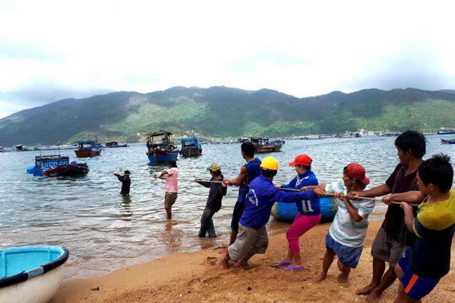 Ngư dân trục vớt, kéo tàu vào bờ ở bãi Lau, Vũng Rô.