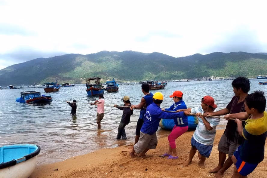 Ngư dân trục vớt, kéo tàu vào bờ ở bãi Lau, Vũng Rô.