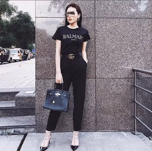 Cách kết hợp quần âu với phụ kiện đồ hiệu bắt mắt chứng tỏ đẳng cấp của người mặc. Cô cũng khéo léo chọn các chi tiết kim loại ánh vàng để làm sáng lên tông đen cho cả trang phục.