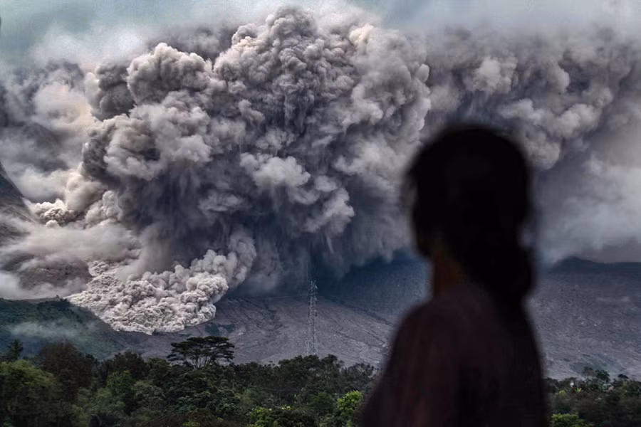 Tuôn trào: Một phụ nữ Indonesia nhìn về phía núi lửa Sinabung đang chực tuôn trào từ làng Tiga Pancur ở Karo, Bắc Sumatra, ngày 3/11. Ảnh: AFP/Getty.