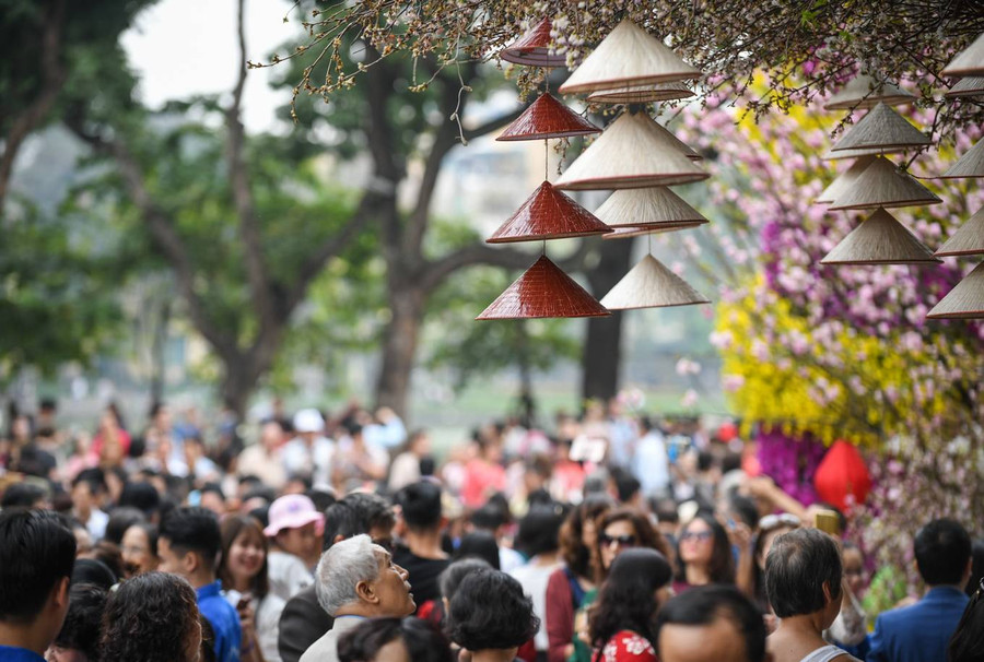 Những chiếc nón lá của Việt Nam treo trên cành anh đào ngay tại cổng vào vườn hoa.