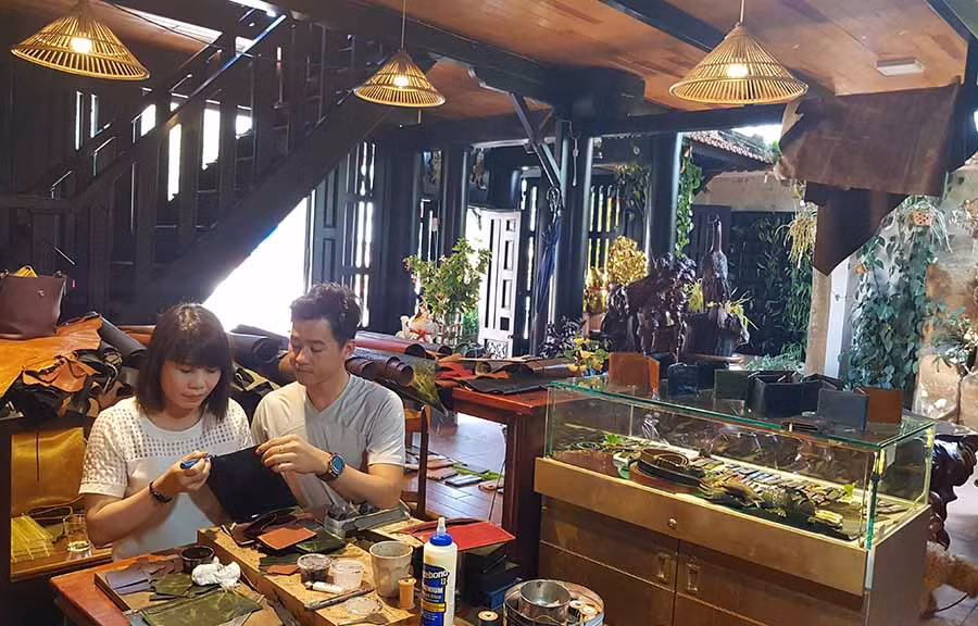  Anh Lê Quang Huy (bìa phải) hướng dẫn một người thợ làm những sản phẩm bằng da thuộc. Ảnh: L.H