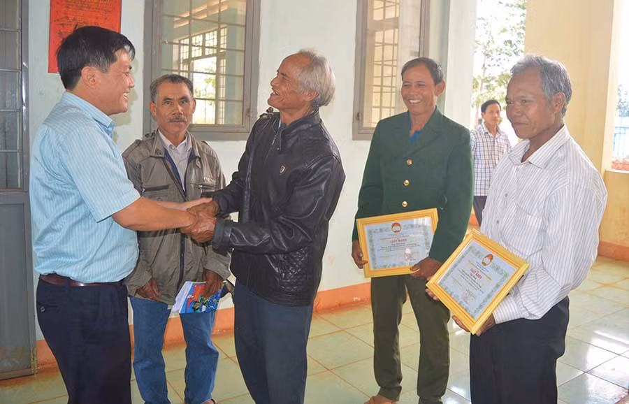  Bí thư Huyện ủy Đak Đoa Nguyễn Hữu Thọ (bìa trái) trao đổi với người uy tín của huyện. Ảnh: Đ.Y