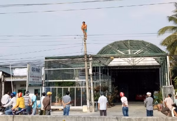  Mất 2 giờ đồng hồ lực lượng chức năng mới giải cứu người đàn ông ngáo đá trèo cột điện