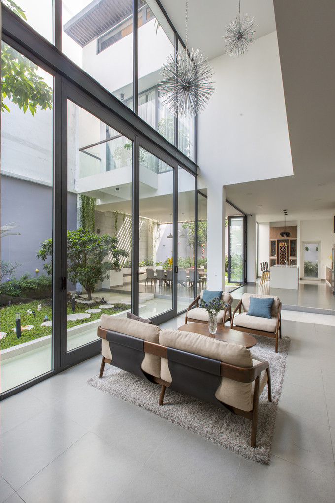 Phòng khách nối liền với khu vực phòng ăn, nhà bếp theo hình chữ L. Nếu tường kính xóa đi ranh giới trong - ngoài thì thông tầng đã xóa nhòa ranh giới giữa bên trên và dưới, giúp phòng khách thông thoáng với không gian mở rộng cả ba chiều. Phòng khách nối liền với khu vực phòng ăn, nhà bếp theo hình chữ L. Nếu tường kính xóa đi ranh giới trong - ngoài thì thông tầng đã xóa nhòa ranh giới giữa bên trên và dưới, giúp phòng khách thông thoáng với không gian mở rộng cả ba chiều.