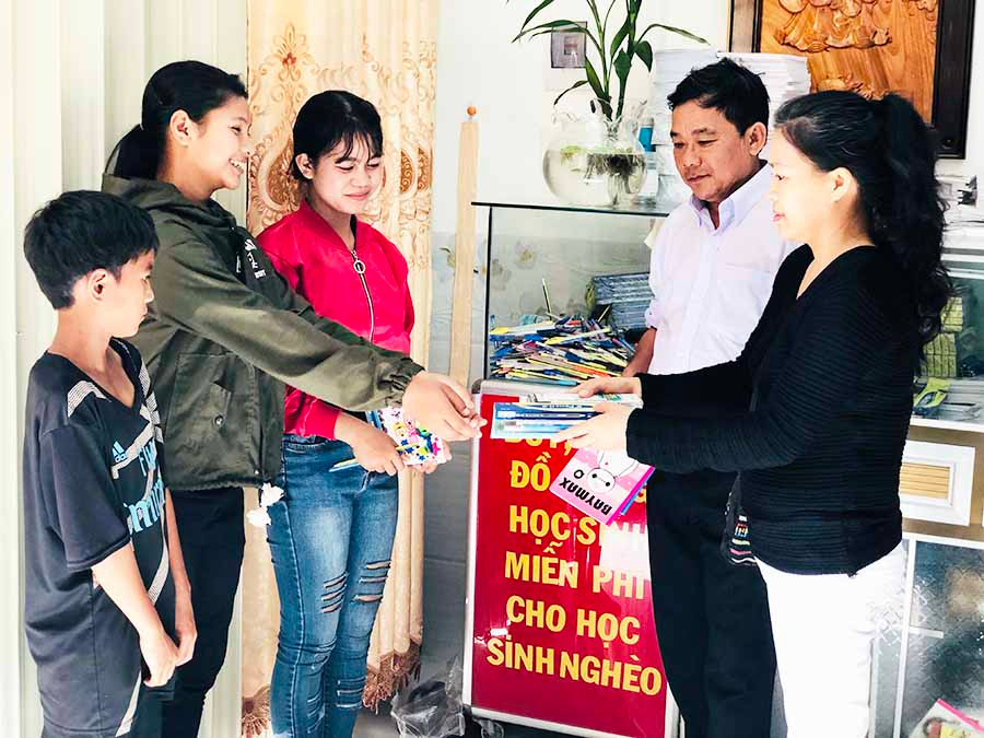  Anh Nguyễn Ngọc Châu và chị Nguyễn Thị Kim Dung tặng bút, vở cho các em học sinh nghèo. Ảnh: P.L