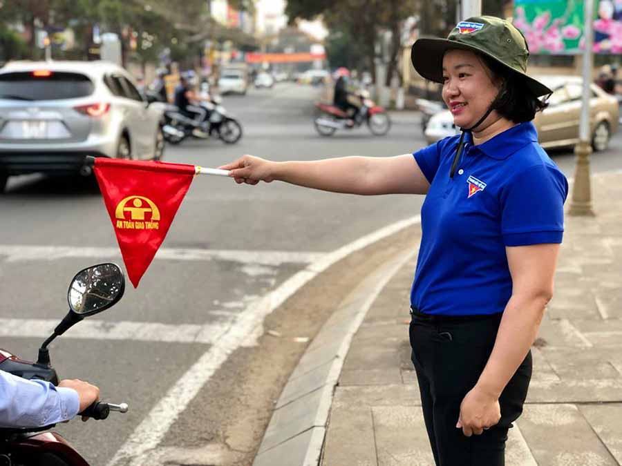  Chị Bùi Thị Mỹ Hạnh trực chốt tại các trụ đèn tín hiệu giao thông vào giờ cao điểm. Ảnh: P.L