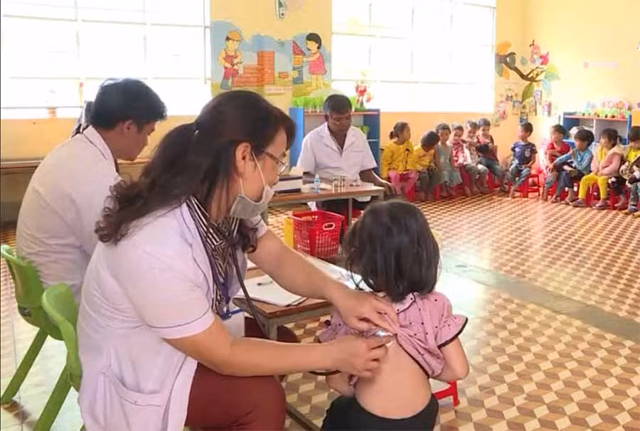  Các bác sĩ khám sàng lọc trước khi tiêm vắc xin cho học sinh Trường Mầm non xã Ia Ka. Ảnh: N.N