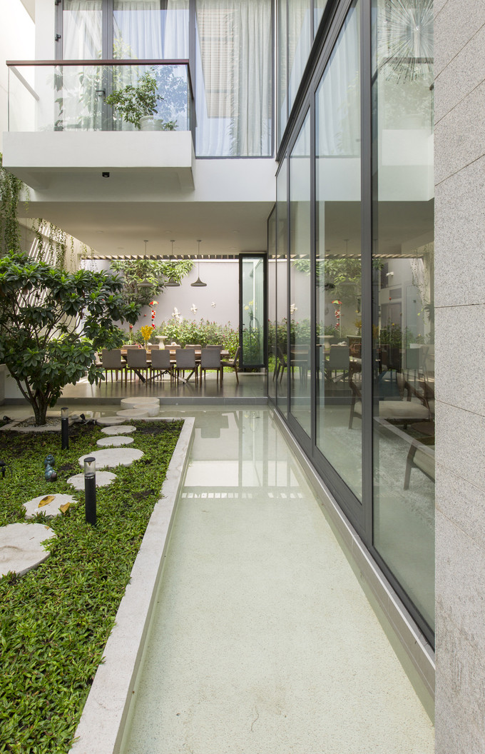 Để các không gian chức năng đều có view nhìn ra sân vườn, các kiến trúc sư đã thiết kế những bức tường kính cường lực. Tường kính giúp xóa nhòa ranh giới giữa bên trong và ngoài nhà, mang không gian sân vườn vào trong nhà và ngược lại. Để các không gian chức năng đều có view nhìn ra sân vườn, các kiến trúc sư đã thiết kế những bức tường kính cường lực. Tường kính giúp xóa nhòa ranh giới giữa bên trong và ngoài nhà, mang không gian sân vườn vào trong nhà và ngược lại.