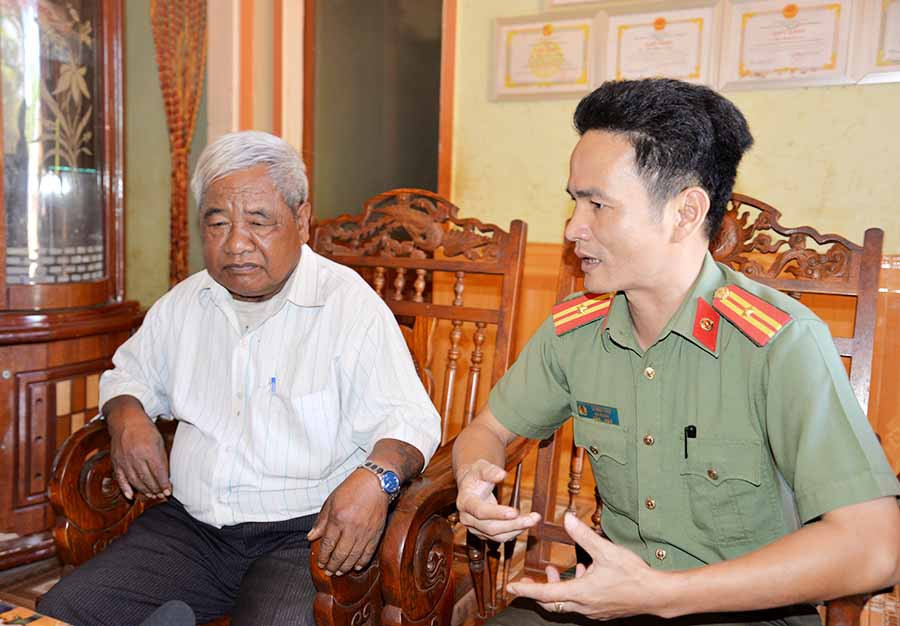  Thiếu tá Lê Ngọc Hưng tranh thủ sự giúp đỡ của già làng Rơ Mah Klua (làng Lâm So, xã Thăng Hưng, huyện Chư Prông) để vận động người dân chấp hành tốt các quy định pháp luật. Ảnh: N.H