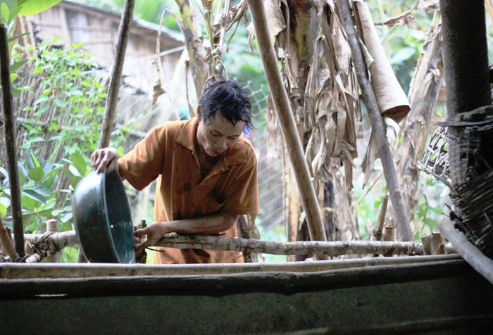  Về tới nhà, anh Lang tất tả cho heo ăn - Ảnh: Trác Rin