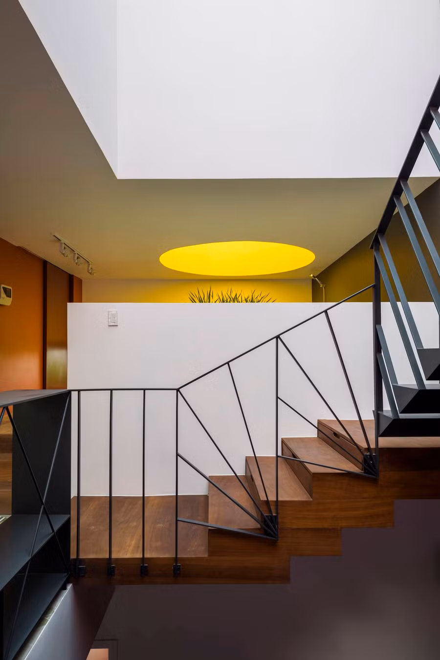  Cầu thang nằm chính giữa nhà, phân chia nhà thành hai phần trước -sau. Cầu thang nhiều màu sắc, nhiều chất liệu (gỗ, thép, bê tông) giúp nó trở thành điểm nhấn trong thiết kế nội thất của ngôi nhà.