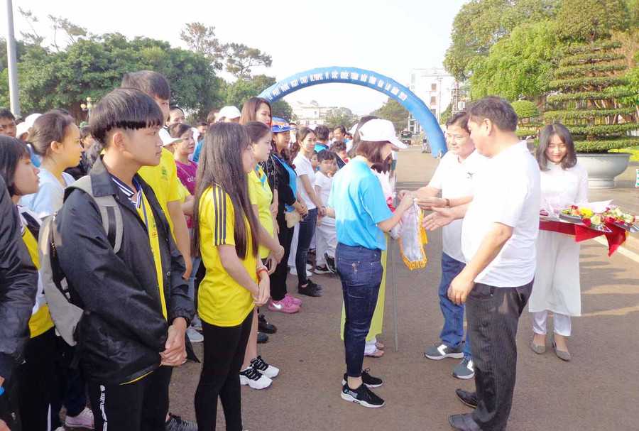 Ban tổ chức tặng cờ lưu niệm và hoa cho các đoàn tham dự. Ảnh: Hà Phương