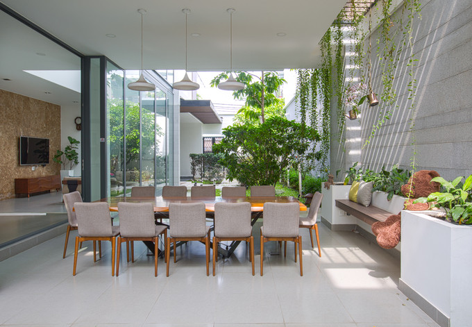 Sự kết nối không gian trong - ngoài còn được nhấn mạnh nhờ khu bàn ăn kê dưới hàng hiên, không có cửa, mở thông với sân vườn Sự kết nối không gian trong - ngoài còn được nhấn mạnh nhờ khu bàn ăn kê dưới hàng hiên, không có cửa, mở thông với sân vườn
