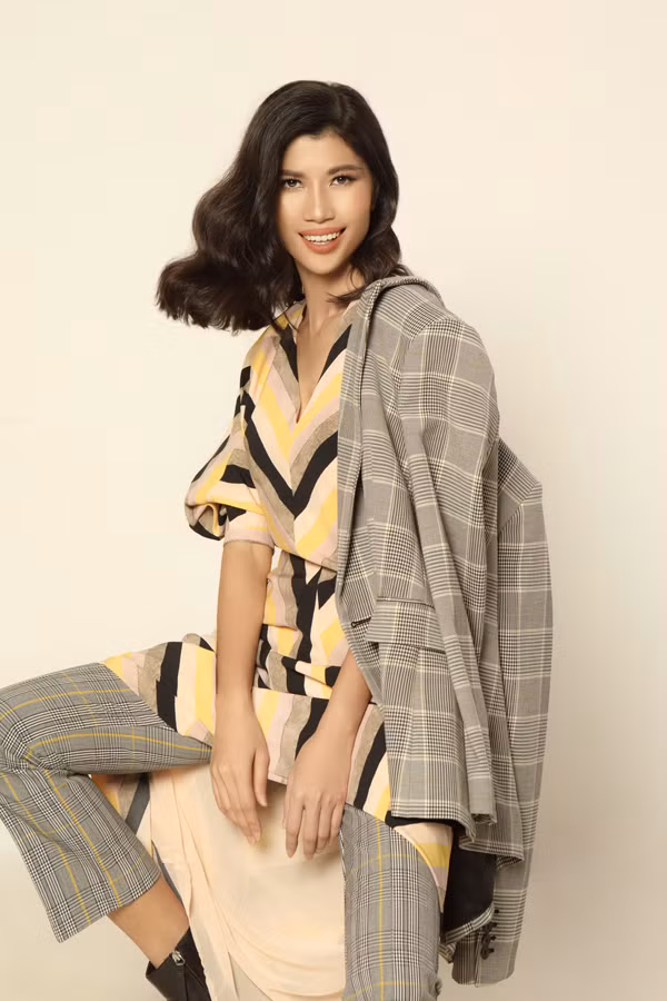  Thay vì phối suit cùng sơ mi hay áo không tay, chân dài 9X chọn đầm liền và vén lên thành áo vạt lệch phóng khoáng.