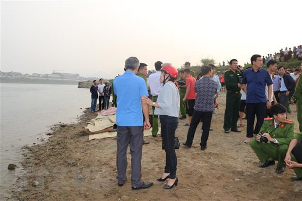 Thi thể được đưa lên bờ, chờ người nhà đến nhận diện. (Ảnh: Nhan Sinh/TTXVN)