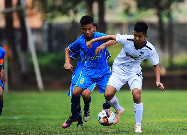Cầu thủ U15 HA.GL (áo trắng) gặp U15 Khánh Hòa (xanh). Ảnh: Minh Trần