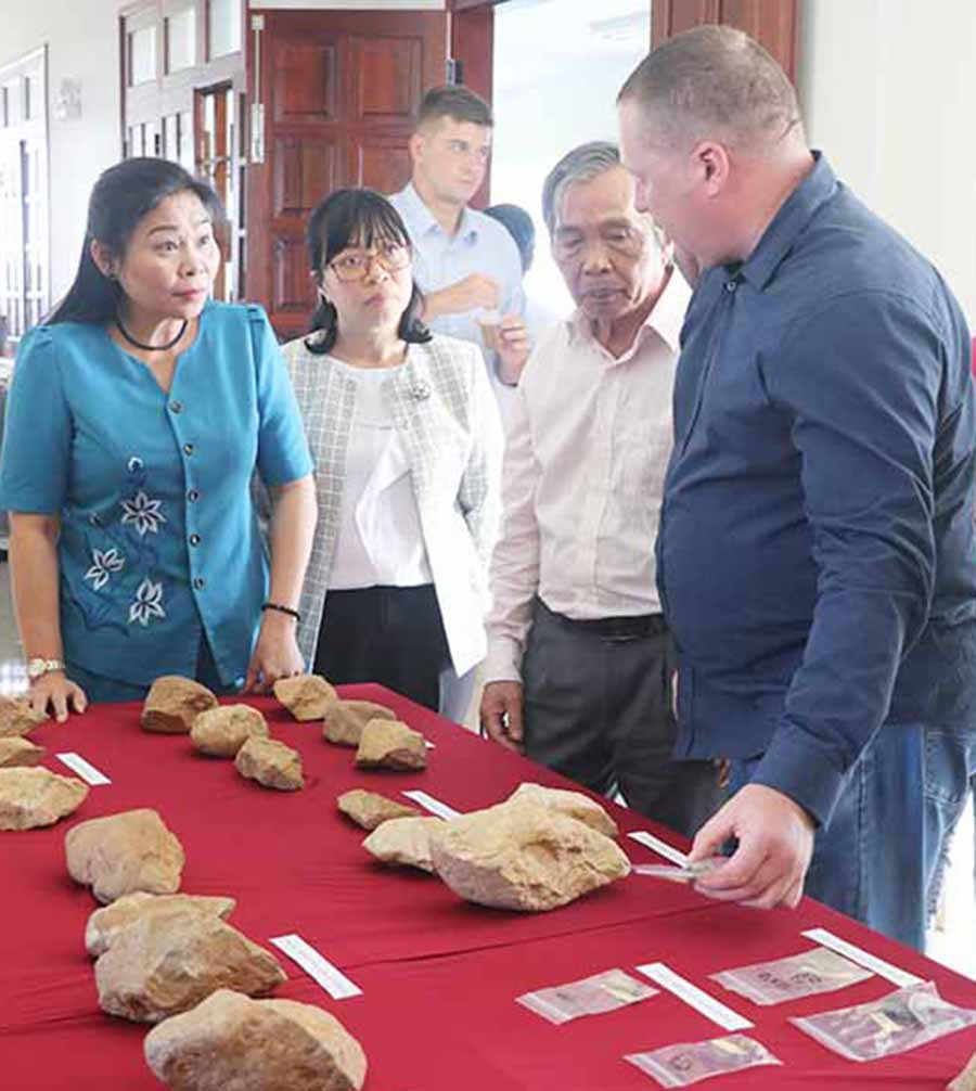 Bà Huỳnh Nữ Thu Hà-Ủy viên Ban Thường vụ Tỉnh ủy, Phó Chủ tịch UBND tỉnh (bìa trái) nghe chuyên gia giới thiệu về các di vật khai quật được tại Di tích Rộc Tưng 4 vào tháng 3-2018. Ảnh: n.m