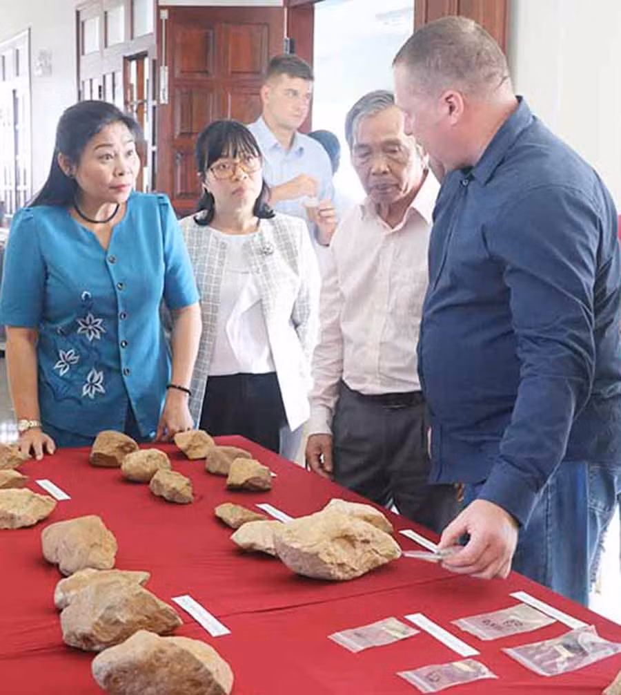 Bà Huỳnh Nữ Thu Hà-Ủy viên Ban Thường vụ Tỉnh ủy, Phó Chủ tịch UBND tỉnh (bìa trái) nghe chuyên gia giới thiệu về các di vật khai quật được tại Di tích Rộc Tưng 4 vào tháng 3-2018. Ảnh: n.m