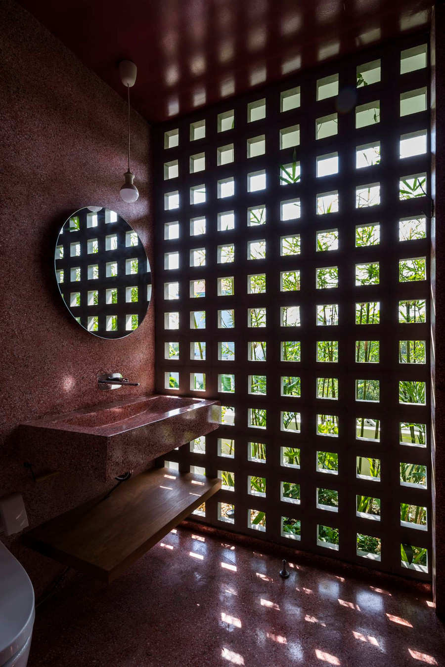  Mặt tiền sử dụng gạch thông gió cùng những hàng tre, vừa giúp ngăn cản ánh sáng mặt trời trực tiếp rọi vào trong nhà vừa tạo ấn tượng thị giác. Gạch thông gió cũng được sử dụng trong nhà, ở những khu vực tường không chịu tải trọng chính, cho phép thông gió chéo trong nhà.