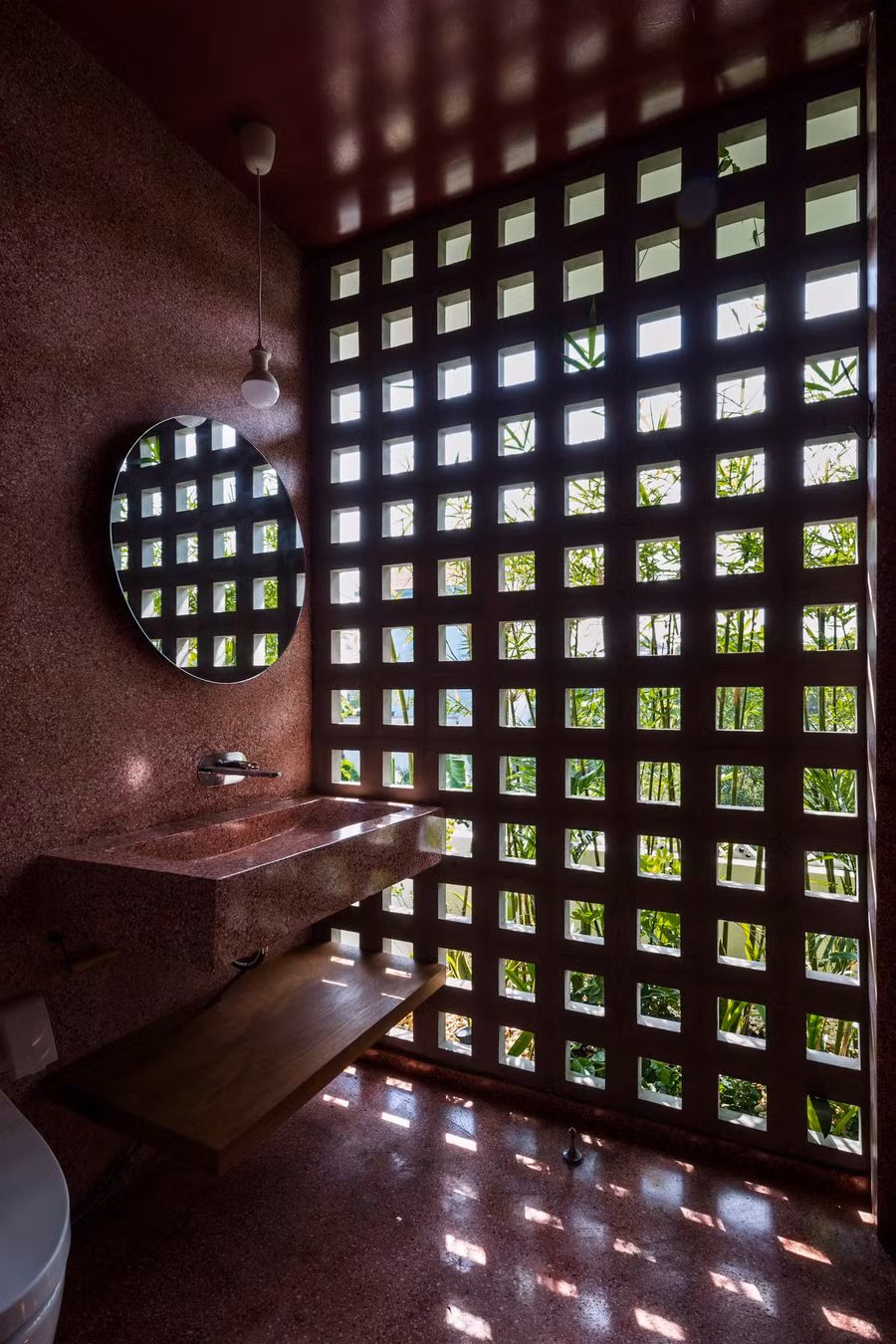  Mặt tiền sử dụng gạch thông gió cùng những hàng tre, vừa giúp ngăn cản ánh sáng mặt trời trực tiếp rọi vào trong nhà vừa tạo ấn tượng thị giác. Gạch thông gió cũng được sử dụng trong nhà, ở những khu vực tường không chịu tải trọng chính, cho phép thông gió chéo trong nhà.