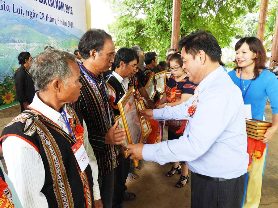 Phó Chủ tịch UBND tỉnh Kpă Thuyên trao bằng khen của Chủ tịch UBND tỉnh cho già làng và người uy tín tiêu biểu. Ảnh: thanh nhật