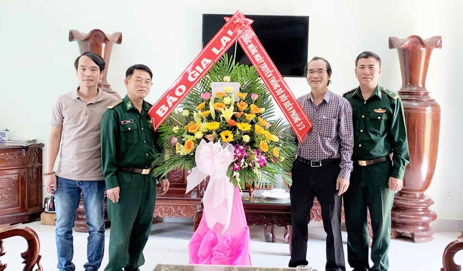 Đồng chí Khuất Đình Viện-Phó Tổng Biên tập Báo Gia Lai (áo kẽ) tặng hoa chúc mừng cán bộ, chiến sĩ bộ đội Đồn Biên phòng Ia Puch. Ảnh: Phương Vi
